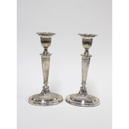 91 - A pair of Edwardian silver candlesticks, of classical design with oval weighted bases, Birmingham 19... 