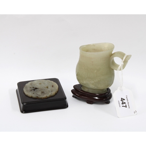 447 - Jade cup with incised lotus pattern, with hardwood stand, 10cm overall together with a hardwood plaq... 