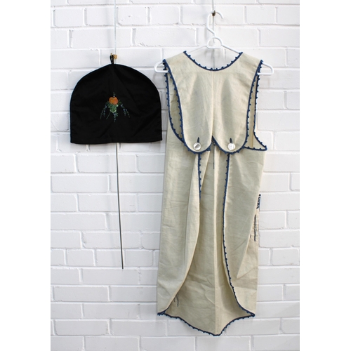 490 - Crewel work pinafore, together with a black embroidered tea cosy (2)