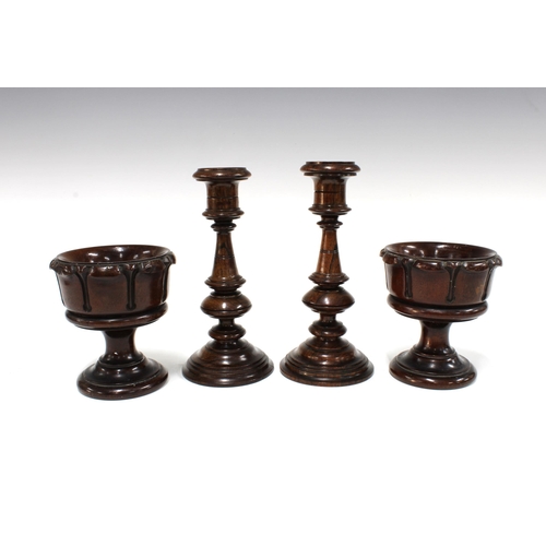 104 - Pair of treen candlesticks, 20cm, together with two treen chalices / salts (4)