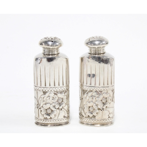 43 - A pair of American silver pepperettes with embossed floral pattern, stamped STERLING 1635, 8cm high ... 