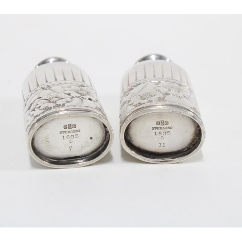 43 - A pair of American silver pepperettes with embossed floral pattern, stamped STERLING 1635, 8cm high ... 