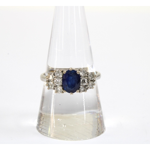 89 - A Sapphire and diamond cluster ring, the claw set sapphire flanked by five smaller diamonds, set in ... 