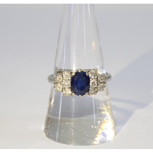 89 - A Sapphire and diamond cluster ring, the claw set sapphire flanked by five smaller diamonds, set in ... 