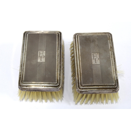 100A - Cased set of two Art Deco silver backed brushes, (2)