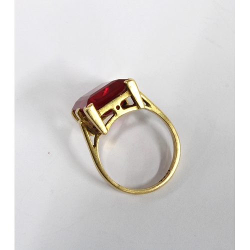 14 - 18ct gold ruby dress ring, the emerald cut ruby in a six claw setting, inner band stamped 18ct, size... 