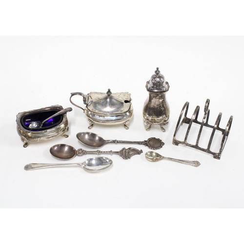 32 - Birmingham silver toastrack, three silver teaspoons, a salt spoon and a three piece silver condiment... 