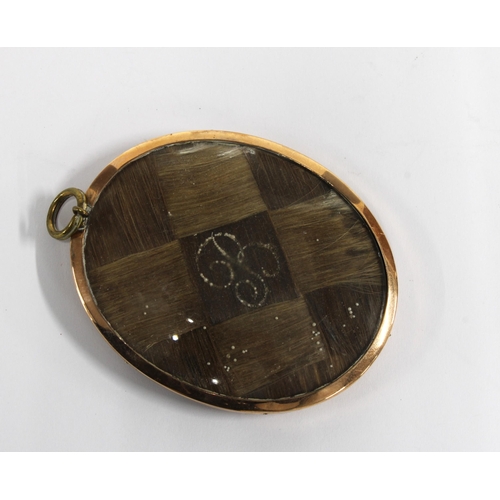 39 - Mourning locket with plaited hair and seed pearls within a yellow metal frame, 7cm