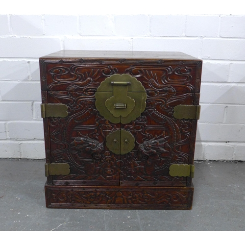 503 - A chinoiserie dragon carved box with brass mounts, the doors opening to reveal an assortment of draw... 