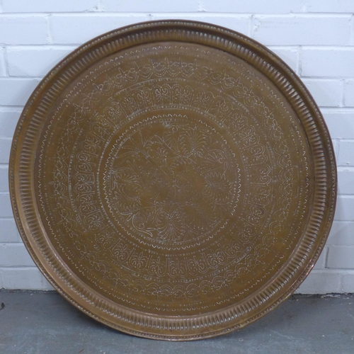 505 - An Eastern copper engraved tray of large circular outline, 78cm diameter,  together with another sma... 