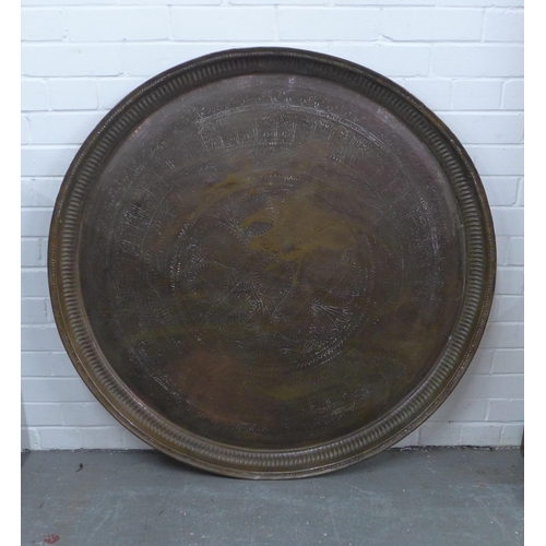 505 - An Eastern copper engraved tray of large circular outline, 78cm diameter,  together with another sma... 