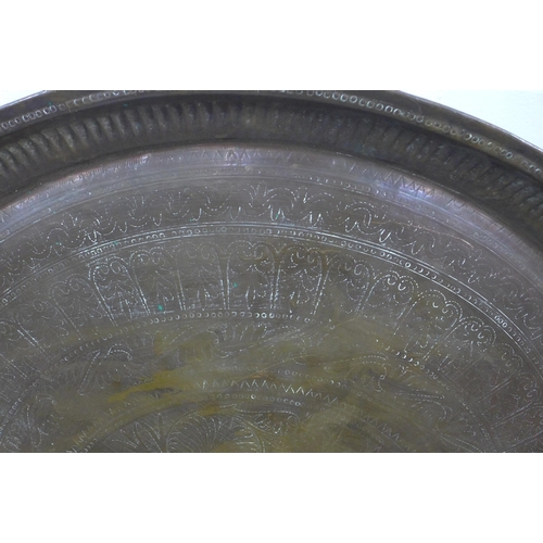 505 - An Eastern copper engraved tray of large circular outline, 78cm diameter,  together with another sma... 