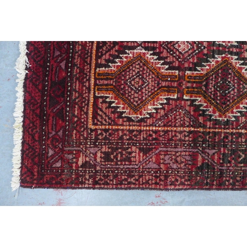 217 - An Afghan Belouch rug with red field 190 x 112cm