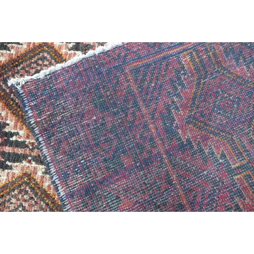 217 - An Afghan Belouch rug with red field 190 x 112cm