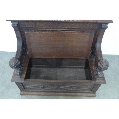 224 - A carved oak bench, with shaped top rail and lion handles, the seat with a lift up compartment, 106 ... 