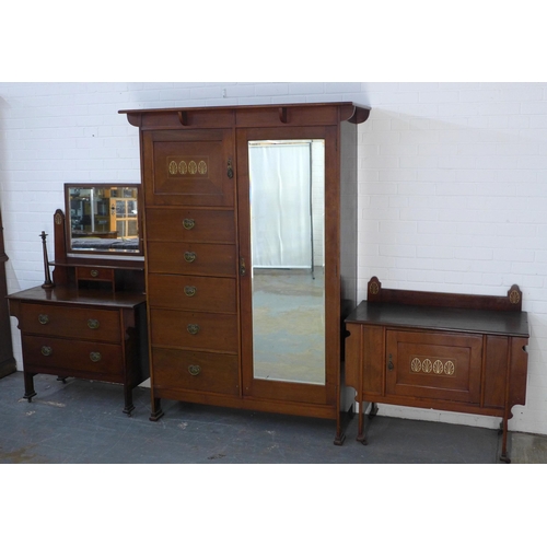 241 - An Arts & Crafts three piece bedroom suite to include a wardrobe, dressing table with candlesticks a... 