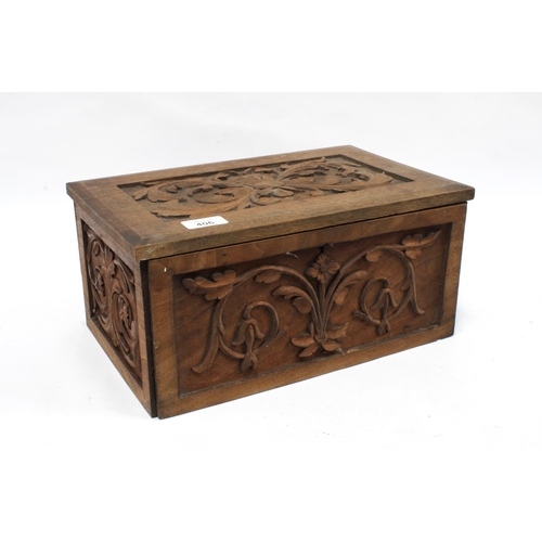 406 - Carved pine Bible box with a collection of Bibles and Prayer Books