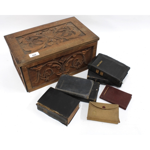 406 - Carved pine Bible box with a collection of Bibles and Prayer Books