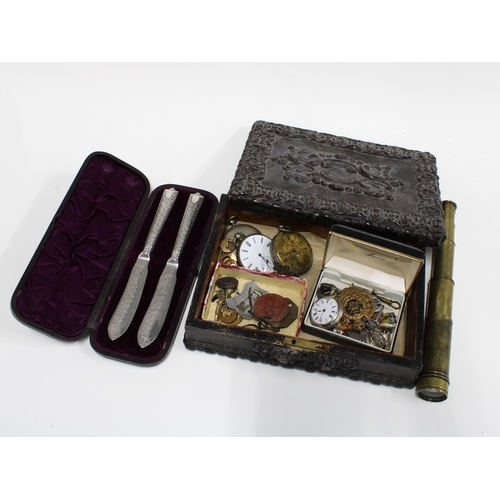 427 - Carved box containing a collection of silver cased and other pocket watches, cap badges, small six d... 