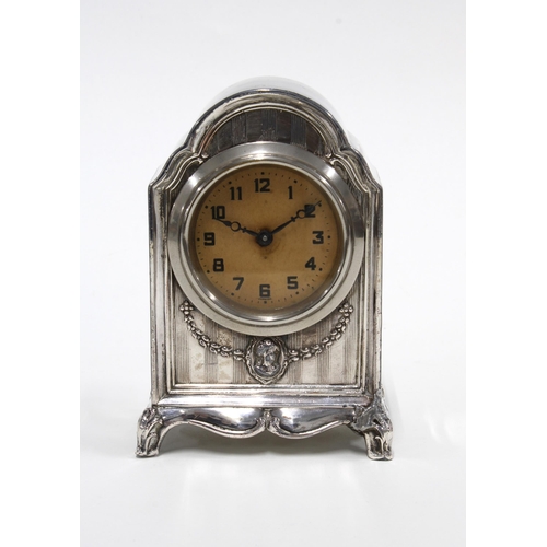 61 - A mantle clock, champagne dial with Arabic numerals, in a white metal case, 12cm