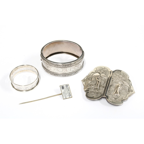 75 - Silver napkin ring, two part chinese buckle, stgiff hinged bangle and a novelty enamel £5 bank note ... 