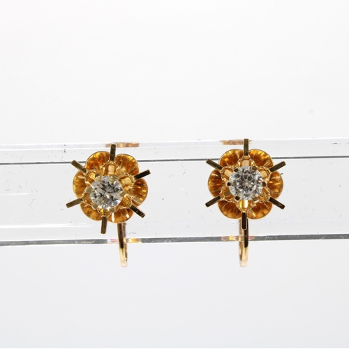 94 - A pair of flowerhead earrings, set in unmarked yellow metal, one stone tests as a diamond, approx 0.... 