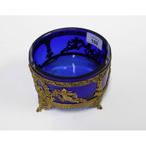 100 - 19th century blue glass bowl in a circular gilt metal stand with cherubs and garlands, on four outsw... 