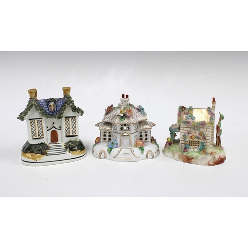 104 - Two Staffordshire pastille burner cottages and a Staffordshire pottery money bank in the form of a h... 