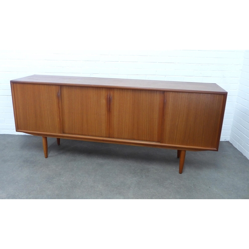 A Danish teak sideboard, by ACO Møbler (Axel Christensen Odder), probably designed by Gunni Omann, with four sliding doors, shelved interior and three pull out slides, 200 x 83 x 47cm.