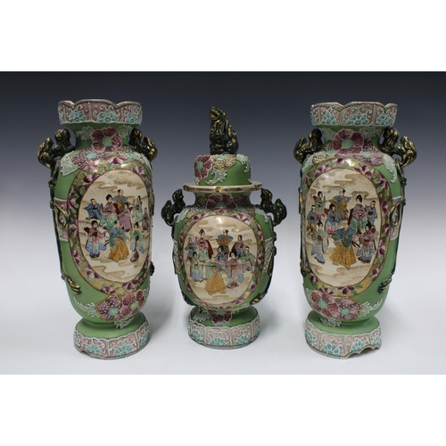 342 - Japanese Moriage garniture of vases with green and pink ground, with foo dog handles and painted fig... 