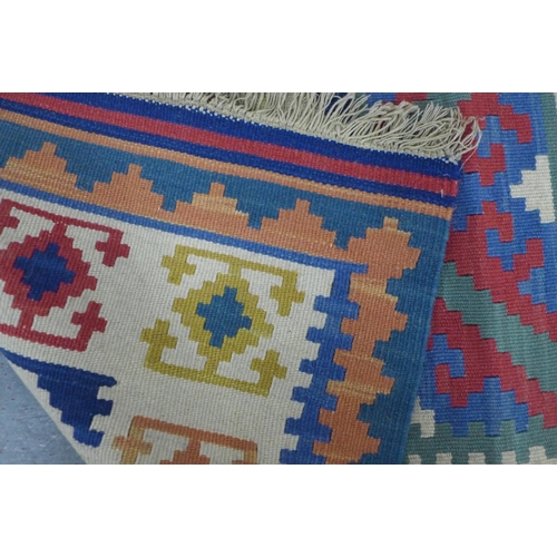 404 - Small kilim rug, 90 x 62cm, together with a wall hanging of a woman in a head wrap (2)