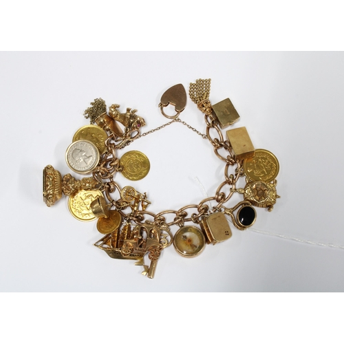 118 - 9ct gold charm bracelet hung with a quantity of charms and coins, to include 15 with 9ct gold hallma... 