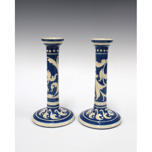 134 - Pair of Torquay Scandy pattern blue and white candlesticks, 22cm (2)