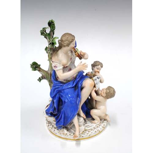 143 - Porcelain figure group representing Music with a female musician and two cherubs, on a circular gilt... 