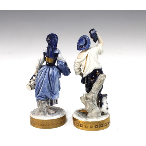 156 - Two Volkstedt porcelain figures of grape picking figures, 20cm (2)