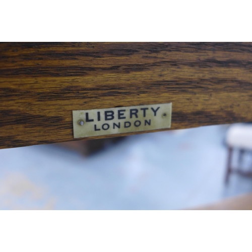 266 - A Liberty and Co Arts and Crafts oak open bookcase with plaque to the back, 83 x 117 x 25cm.