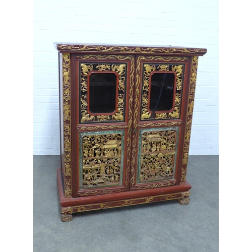 277 - Chinese giltwood and red lacquered cabinet, two doors with shelved interior,  x 126 x 54cm.