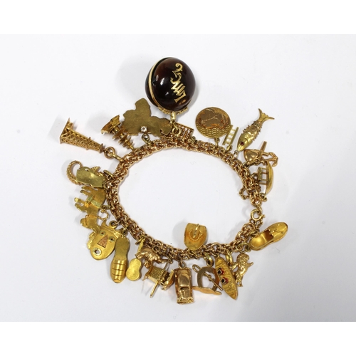 31 - 18ct bracelet, stamped 750 & 18k, hung with a quantity of charms to include nine 18ct charms, three ... 