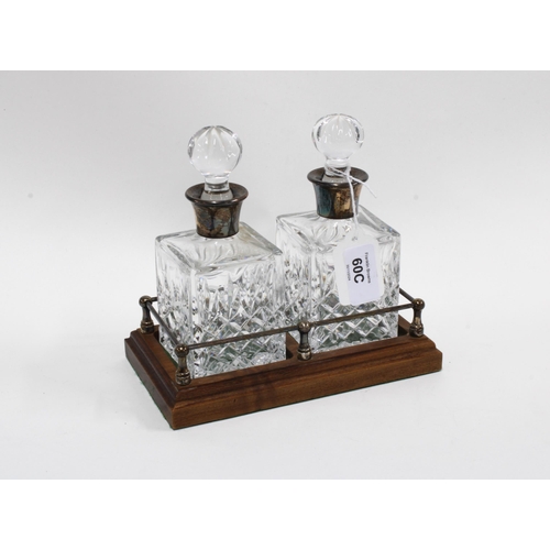 60C - A pair of small glass decanters with stoppers and silver collars, with  a wooden stand, Birmingham 1... 