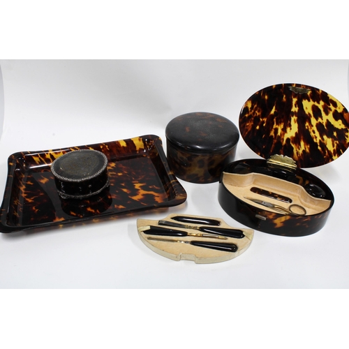 60F - An Edwardian silver mounted tortoiseshell box and a tortoiseshell manicure set in an oval box with a... 