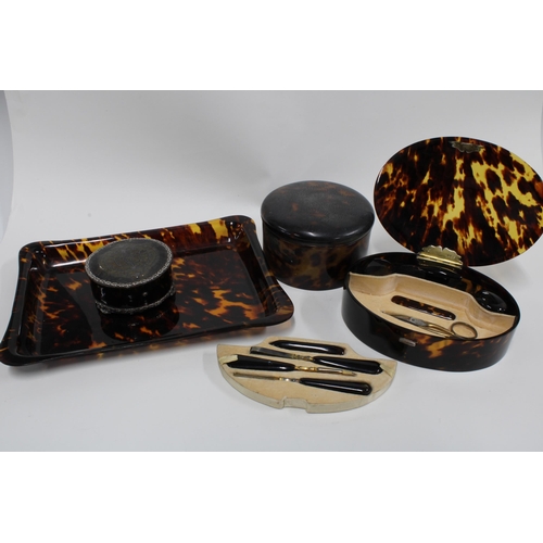 60F - An Edwardian silver mounted tortoiseshell box and a tortoiseshell manicure set in an oval box with a... 