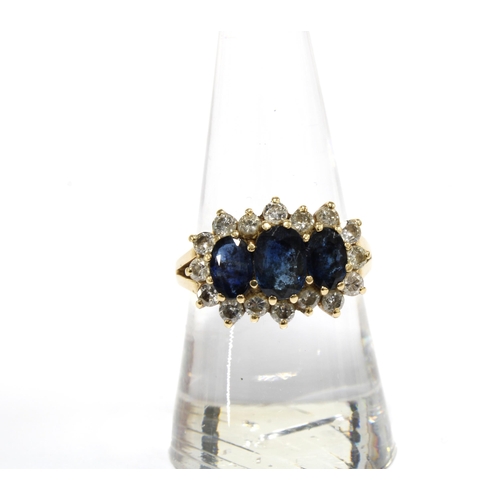 63 - Sapphire and diamond dress ring, claw set with three sapphires within a surround of smaller diamonds... 