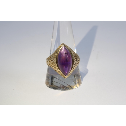 70 - A vintage 9ct gold ring with a amethyst cabochon in a floral engraved setting, London 1973, size T