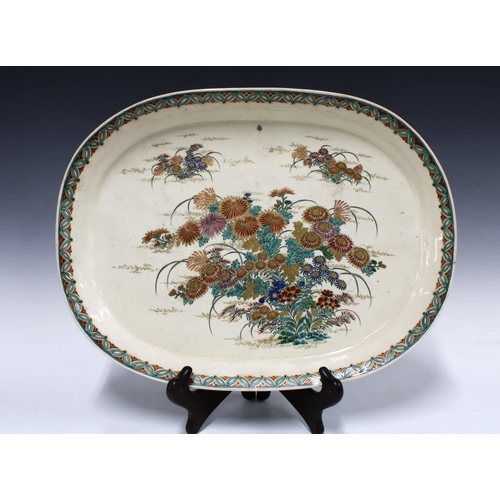 138 - An early 20th century Japanese Satsuma serving dish / ashet, finely painted with chrysanthemums and ... 