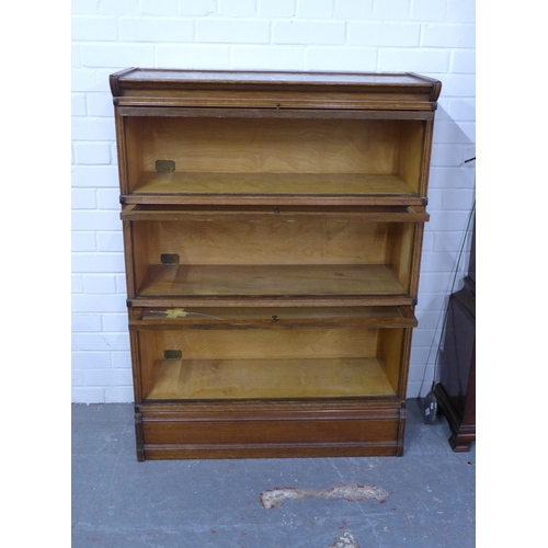 286 - Inglesants oak three tier sectional bookcase, with glass fronts and brass label. (two glass panes a/... 