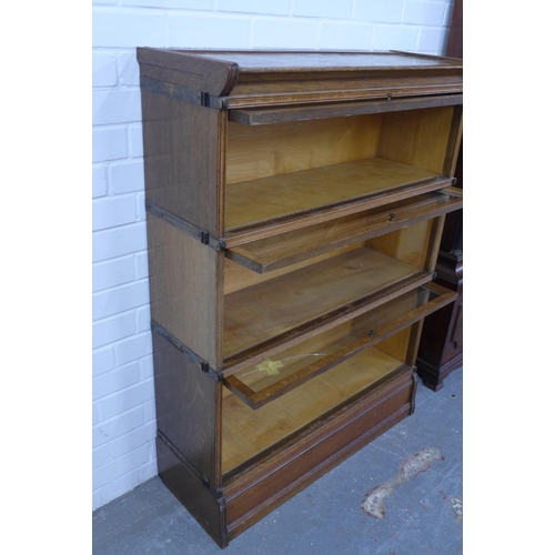 286 - Inglesants oak three tier sectional bookcase, with glass fronts and brass label. (two glass panes a/... 