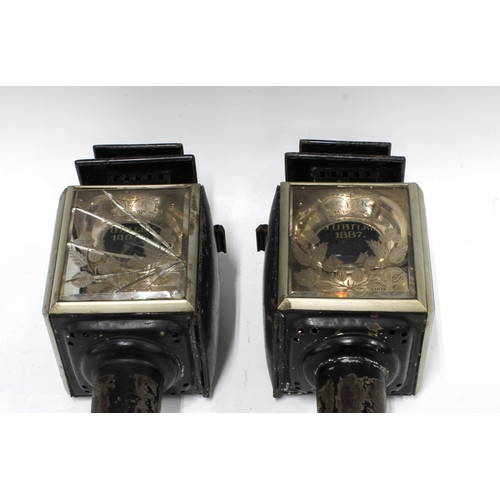 385 - Pair of Victorian VR Jubilee 1887 black metal and glass panelled carriage lanterns, one with the gla... 