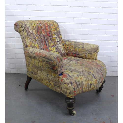 298 - Country House upholstered armchair, with later floral cover, mahogany legs with brass caps and casto... 