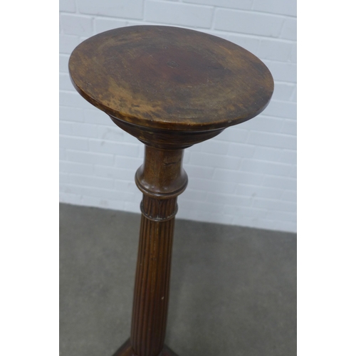 202 - Mahogany torchere stand, circular top on a fluted column, 31 x 123cm.