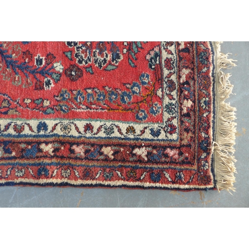 222 - Persian wool rug, red foliate field, 202 x 103cm